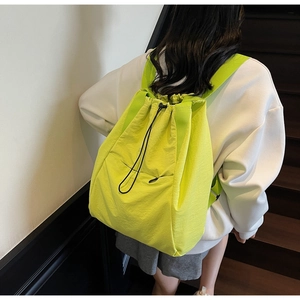 Detailed view of neon green drawstring backpack made of lightweight waterproof nylon fabric