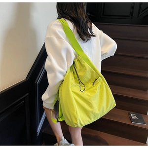 Detailed close-up of vibrant neon nylon tote bag with drawstring closure on model