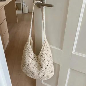 Detailed close-up of beige crochet tote bag with hollow woven pattern and inner lining