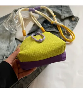 Detail of trendy bucket bag with neon mesh fabric, purple base, and thick woven shoulder strap