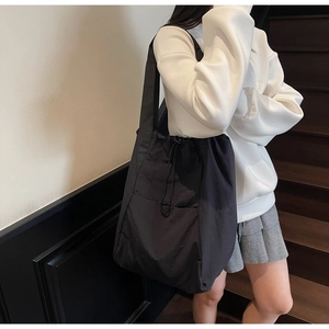 Detailed view of the black drawstring shoulder bag with a large capacity and side pocket