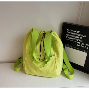 Detail of neon green drawstring backpack made of lightweight crinkled nylon fabric