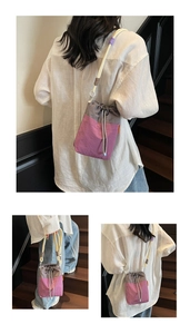 Detail view of purple checkered drawstring bucket bag with thick cotton shoulder strap