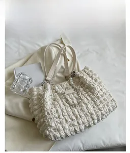 Detail of white puff bubble tote bag with pearl chain and leather shoulder strap