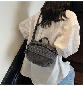 Détail du sac bandoulière en denim délavé montrant la texture du tissu et la sangle