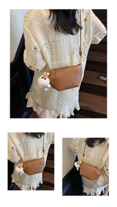 Detail of vintage brown leather crossbody bag with a cute white plush bear pendant accessory