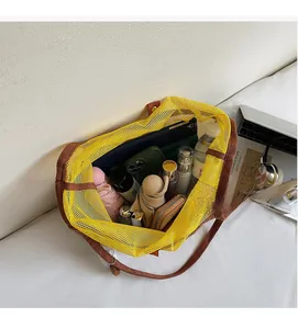 Macro shot showing high capacity of yellow mesh tote bag with brown straps and daily essentials