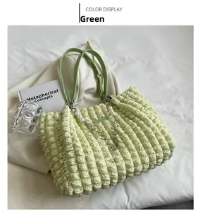 Detail of light green ruched tote bag with bubble fabric texture and pearl strap