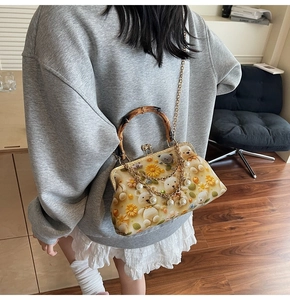 Detail of bear pattern floral bag with bamboo handle and pearl chain strap