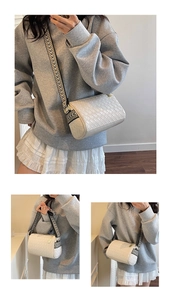 Detail of off-white woven pillow bag with geometric wide strap and metal zipper closure