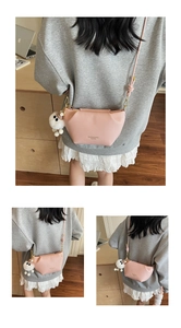 Detail of pink pleated cloud bag with leather strap and plush white eye keychain accessory