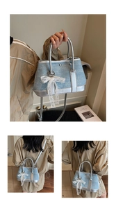 Detail of blue denim crossbody bag with silver trim and white lace bow decoration