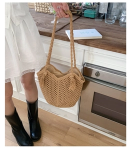 Detailed close-up of khaki mesh woven tote bag with fringe tassels and shoulder straps
