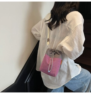 Detail of drawstring shoulder bag with grey and pink color-block and checkered texture