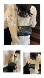 Detail of woven black crossbody bag featuring a wide geometric pattern fabric strap