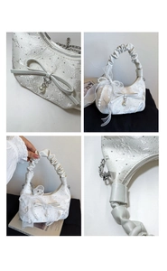 Detailed macro view of white textured handbag with floral embroidery and pearl bow charms