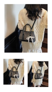 Detail view of a black sequin handbag featuring a white lace bow charm and leather straps