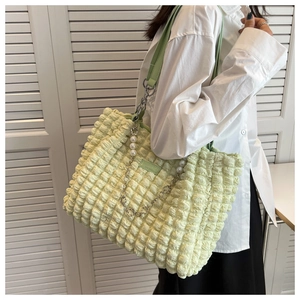 Detail of light green bubble texture tote bag with pearl flower chain and leather strap