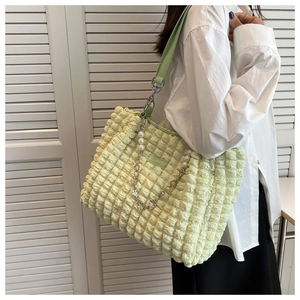 Detail of light green bubble pleated tote with pearl chain strap and leather shoulder handle