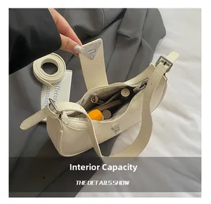 Detail of off-white pleated shoulder bag interior showing compartments and zipper pocket