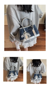 Detail of denim bucket bag with silver trim and white lace bow accessory for women
