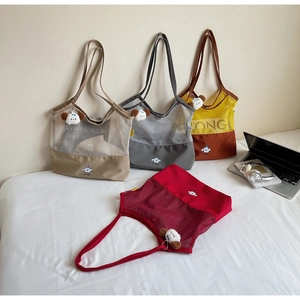 Detailed view of colorful mesh patchwork tote bags with cartoon dog prints and plush charms