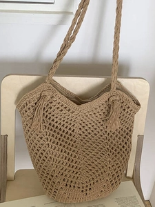 Large crochet knit shoulder bag with hollow mesh design and stylish tassel charms