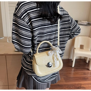 Vue détaillée du sac bandoulière plissé crème avec décoration de nœud en dentelle perlée