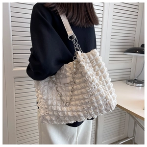 Close-up of off-white bubble pleated tote bag with pearl and floral metal chain details