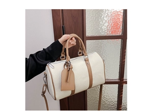 Detail of Boston handbag showing lychee pattern leather texture and contrast brown trim