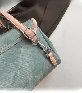 Detailed close-up of pink leather trim and polished silver hardware on blue denim backpack