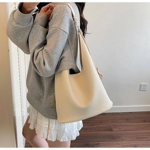 Close-up of beige lychee texture PU leather hobo bag with wide shoulder strap
