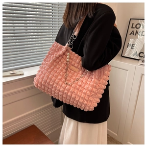 Detail showing pink bubble textured tote bag with elegant pearl and metal chain strap