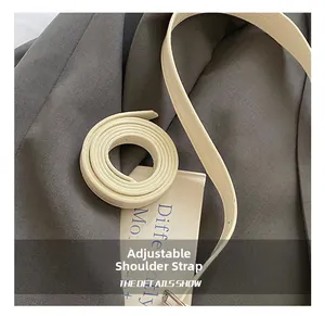 Detail of adjustable cream leather strap with fine litchi grain and precise stitching