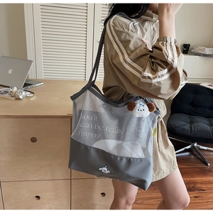 Detail of grey mesh tote bag featuring a cute cartoon dog print and plush keychain