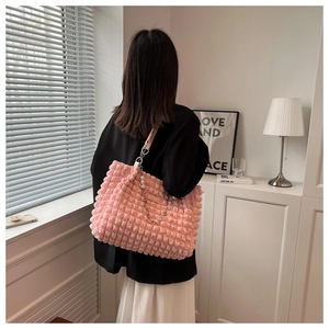 Detail shot of puffy pink bubble texture bag with large pearl strap and silver chain link