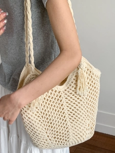 Large beige crochet tote bag with woven hollow mesh and tassel charm for summer beach