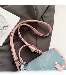 Detail of pink leather straps and light blue denim fabric texture on a casual backpack