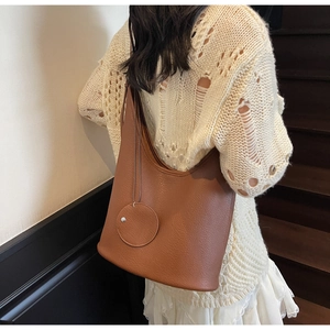 Detailed macro of brown lychee grain leather underarm bag with matching round coin purse