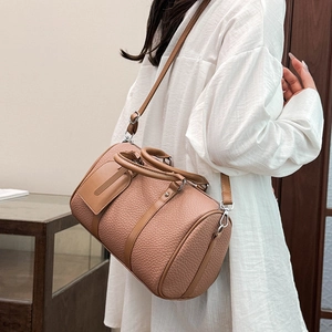 Close-up of brown litchi grain leather Boston bag with dual handles and shoulder strap