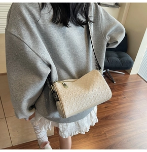 Detail of cream woven pillow bag with ethnic patterned strap and leather texture