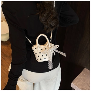 Detailed back view of a mini polka dot handbag with lace and pearl bow decoration