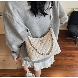 Gros plan d'un sac bandoulière matelassé beige avec losanges et petits strass brillants