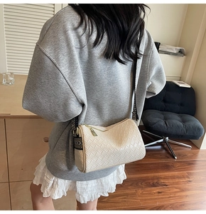 Detail of cream woven pillow bag with ethnic style jacquard strap and gold zipper