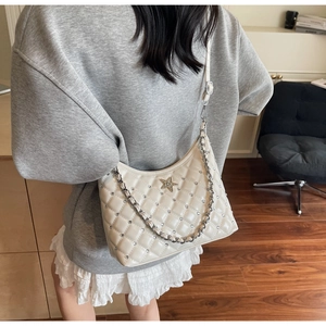 Vue détaillée du sac matelassé blanc avec étoile argentée et strass brillants