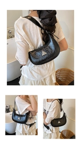 Detail of black crescent hobo bag featuring glossy wrinkled texture and silver triangle buckle