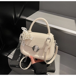 Détail du mini sac blanc avec breloque cœur en perles et texture en cuir craquelé