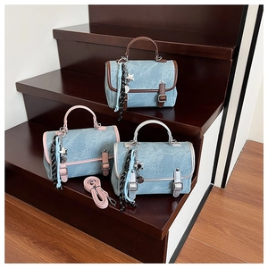Detailed close-up of denim handbags with leather trim, featuring star charms and top handles