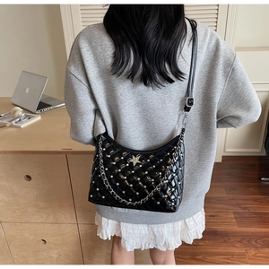 Détail du sac bandoulière noir matelassé avec motifs en losange, strass et décor d'étoile