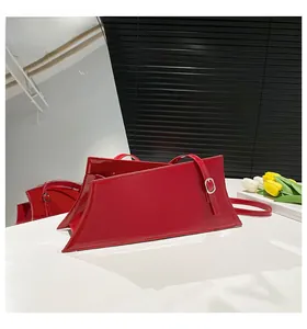 Detailed view of glossy red patent leather handbag with silver metallic buckle detail
